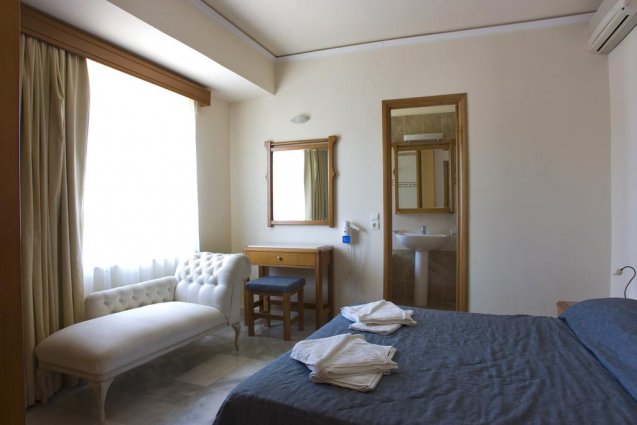 Tweepersoonskamer met bed en sofabank van appartementen Furtura vakantie Kreta